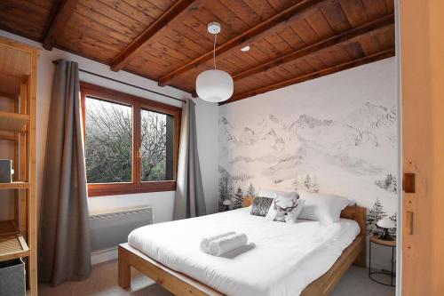 une chambre avec un grand lit blanc et une fenêtre dans l'établissement Les Fleurs de Cham - Jardin vues - Rénové, à Chamonix-Mont-Blanc