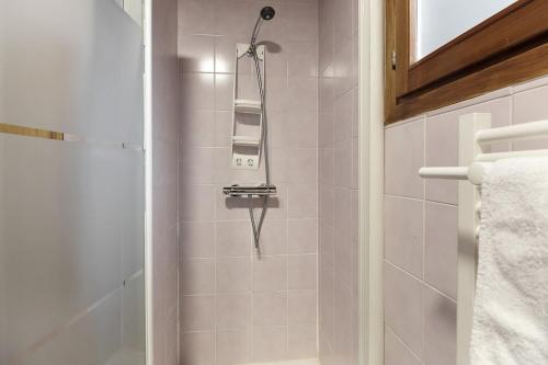 La salle de bains est pourvue d'une douche et d'une serviette. dans l'établissement Les Fleurs de Cham - Jardin vues - Rénové, à Chamonix-Mont-Blanc