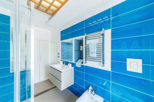 a blue bathroom with a sink and a toilet at Casa Mare & Relax in Pozzuoli