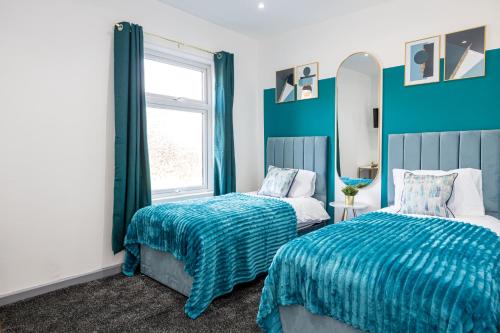 a bedroom with two beds and a window at Bolton 2BR Cinema House, Free Parking, Fast WiFi, Comfortable Stay in Bolton
