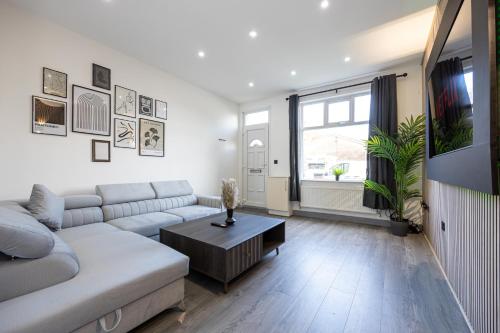 a living room with a couch and a table at Bolton 2BR Cinema House, Free Parking, Fast WiFi, Comfortable Stay in Bolton