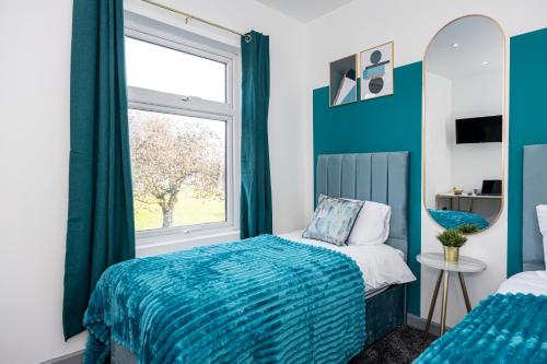 een slaapkamer met een bed en een raam bij Stunning Bolton Abode - Cinema Experience - Parking in Bolton