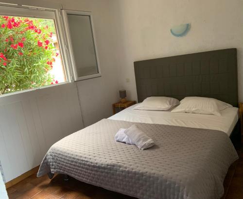 une chambre avec deux lits et une fenêtre dans l'établissement Résidence U LATONU, à Porto-Vecchio