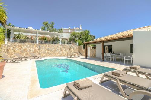 a villa with a swimming pool and a house at Villa Redonda by Algarve Holidays in Loulé