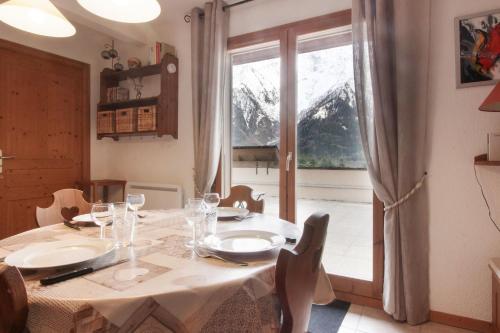 une salle à manger avec une table et une grande fenêtre dans l'établissement Betulle - 2bedroom - Patio facing Mont-Blanc range, aux Houches