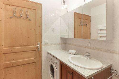 une salle de bain avec un lavabo et une machine à laver dans l'établissement Betulle - 2bedroom - Patio facing Mont-Blanc range, aux Houches