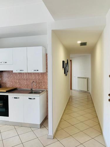a kitchen with white cabinets and a tile floor at A Casa Di Carolina in Cassino