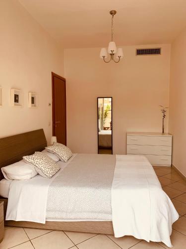 a bedroom with a large white bed and a chandelier at A Casa Di Carolina in Cassino