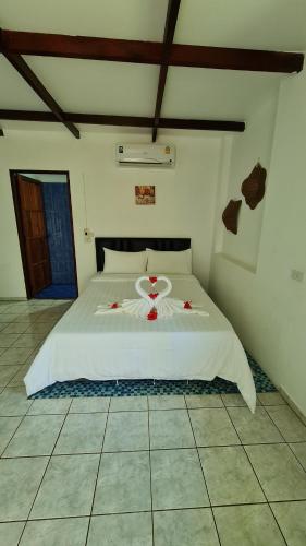 a bedroom with a white bed with red flowers on it at Koh Mak Garden View in Ko Mak