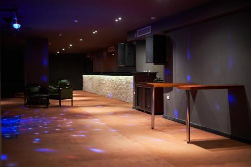 a dark room with a stage with chairs and a counter at Gravity Hotel & Aqua Park Hurghada Families and Couples Only in Hurghada