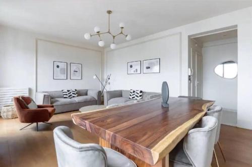 un salon avec une table et des chaises en bois dans l'établissement Avenue Montaigne Luxury Apartment 2BR 4P, à Paris