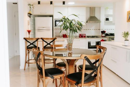 Completo apartamento em Resort na beira da lagoa في فلوريانوبوليس: مطبخ مع طاولة وكراسي زجاجية