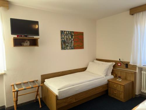 a small bedroom with a bed with a tv on the wall at PANORAMA SportHOTEL in Folgaria