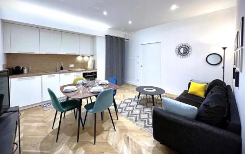 un salon avec un canapé et une table et une cuisine dans l'établissement Hypercentre Charmant 2 Chambres Au Calme avec Joli Patio Privatif, à Nantes