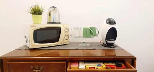 a microwave sitting on top of a wooden cabinet at Hostal Urban Basic in Hospitalet de Llobregat