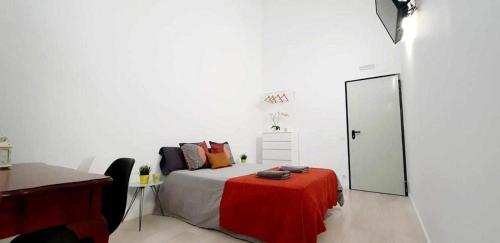 a bedroom with a bed with a red blanket on it at Hostal Urban Basic in Hospitalet de Llobregat