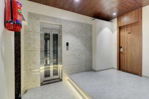 - une douche à l'italienne dans une chambre avec porte dans l'établissement Hotel Archith, à Navi Mumbai