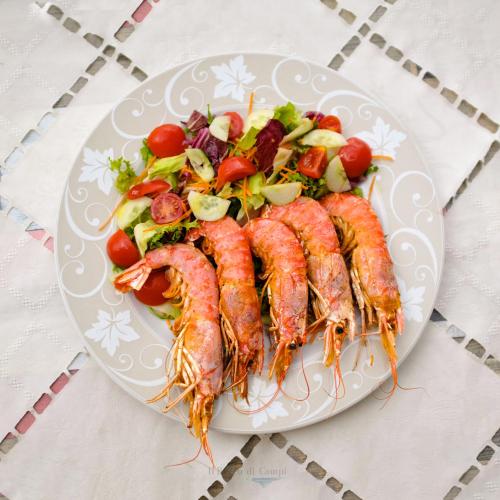 a plate of shrimp and a salad on a table at Il Borgo Di Campi in Riomaggiore