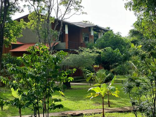a house in the middle of a yard with trees at Sigiriya Cottage in Sigiriya