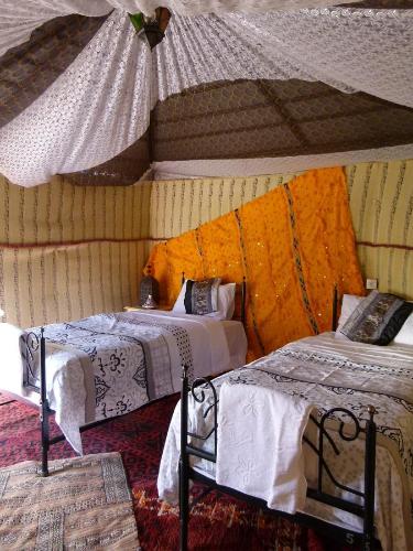 a bedroom with two beds and a ceiling at Morocco Deluxe Camp - Assif n'Itrane in Lac Yasmins
