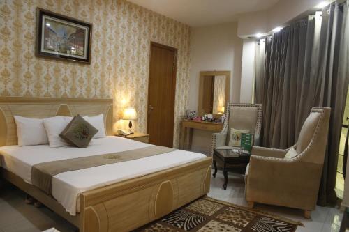 a bedroom with a bed and a desk and a chair at Park View Hotel Gulberg in Lahore