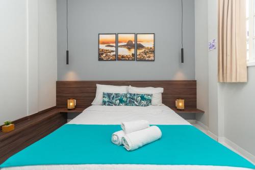 a bedroom with a blue bed with two towels at Bamboo Rio Hostel in Rio de Janeiro