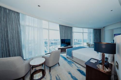 a hotel room with a bed and a large window at Century Marina Hotel - Lusail in Lusail