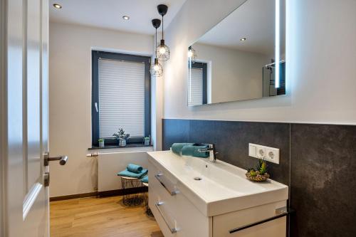 ein Bad mit einem Waschbecken und einem Spiegel in der Unterkunft Casa Caso - Apartment 4 in Achim