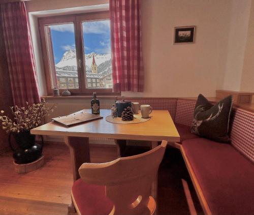 a room with a table and a couch and a window at Haus Wallis by stayFritz - Ski-In Ski-Out Zimmer 'garni' am Arlberg in Warth am Arlberg