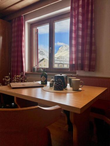 a table with a window with a view of a mountain at Haus Wallis by stayFritz - Ski-In Ski-Out Zimmer 'garni' am Arlberg in Warth am Arlberg