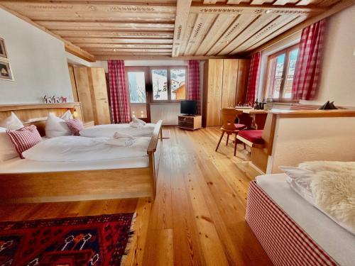 a large room with two beds and a desk at Haus Wallis by stayFritz - Ski-In Ski-Out Zimmer 'garni' am Arlberg in Warth am Arlberg