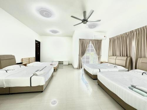 a room with four beds and a ceiling fan at Tanjung Bungah 6BR 20Pax Bungalow w/ Snooker BBQ in Tanjung Bungah