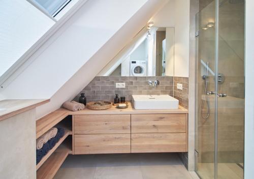 uma casa de banho com um lavatório e uma cabina de duche em vidro. em Sunshine Suite - mit Meerblick em Timmendorfer Strand