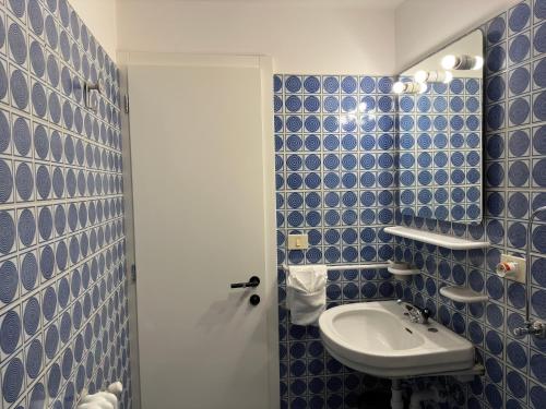 a bathroom with blue tiled walls and a sink at PANORAMA SportHOTEL in Folgaria