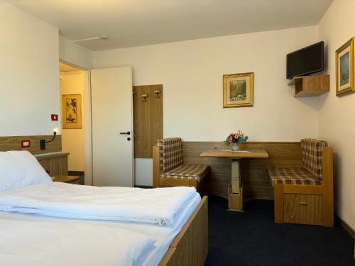 a hotel room with a bed and a table and chairs at PANORAMA SportHOTEL in Folgaria