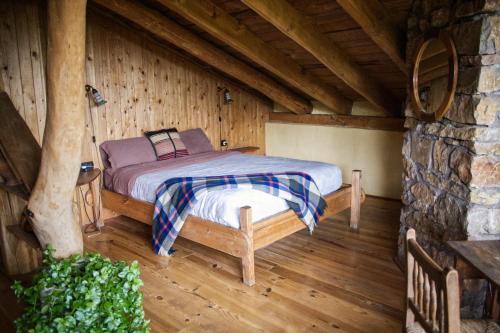 um quarto com uma cama num chalé de madeira em Cal Serrat em Abella de la Conca