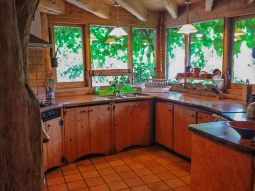 a large kitchen with wooden cabinets and windows at Cal Serrat in Abella de la Conca