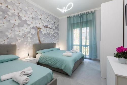 1 dormitorio con 2 camas y pared de flores en Vatican Home with Balcony, en Roma