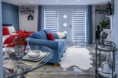 a living room with a blue couch and a table at Modern and Stylish 1-Bedroom Guesthouse near M6 J10 Perfect for Business Stays & Couples Free Parking & Wi-Fi in Willenhall