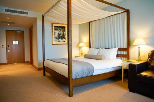 فندق غولف وسبا بيستر في بيسستر: غرفة نوم بسرير مظلة في غرفة الفندق
