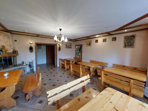 an empty restaurant with wooden tables and benches at АртГір гостинний двір in Mykulychyn