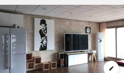 a living room with a flat screen tv on a wall at Yesan Sarang Pension in Hongseong