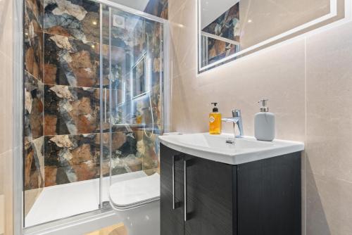 a bathroom with a sink and a shower and a toilet at Stylish Sparkling Brand New 2 bed house in Heston