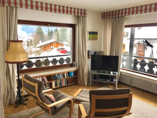 sala de estar con ventana grande y TV en Fewo Karwendelglühen, en Mittenwald