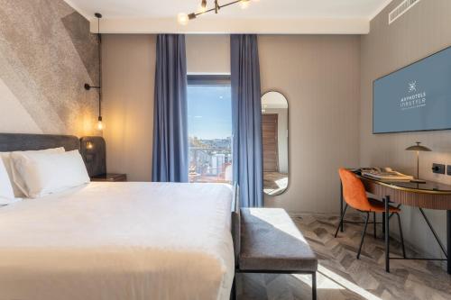 una camera d'albergo con letto, scrivania e finestra di AXYHOTELS InnStyle Milano a Milano