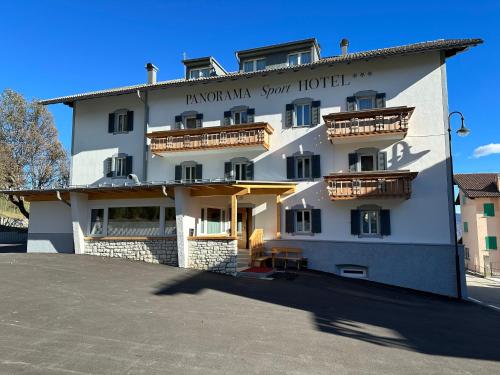 a large white building with balconies on it at PANORAMA SportHOTEL in Folgaria