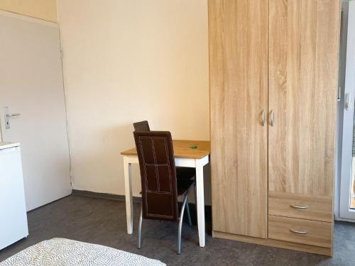 馬爾克泰登費爾德的住宿－Monteurpension Monika，一张桌子和椅子,旁边是木柜