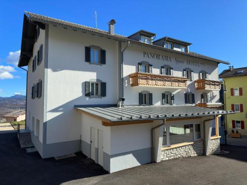 a large white building with a balcony at PANORAMA SportHOTEL in Folgaria