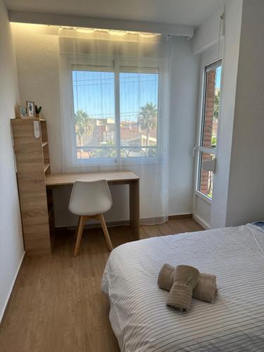 1 dormitorio con cama, escritorio y ventana en El Balcón de Príncipe, en Alcantarilla