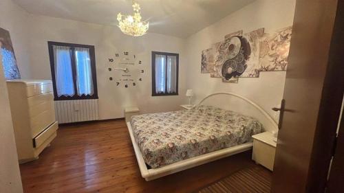 TrepontiにあるAPPARTAMENTO PANORAMICOのベッドルーム1室(ベッド1台付)が備わります。壁には絵画が飾られています。